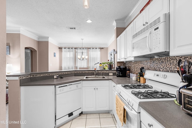 kitchen with white cabinets, kitchen peninsula, a notable chandelier, and white appliances