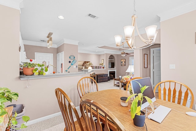 dining space featuring light colored carpet, crown molding, and ceiling fan with notable chandelier