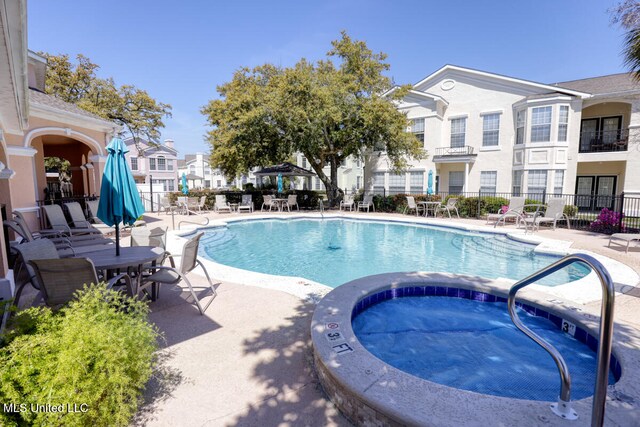 view of pool featuring a hot tub and a patio area