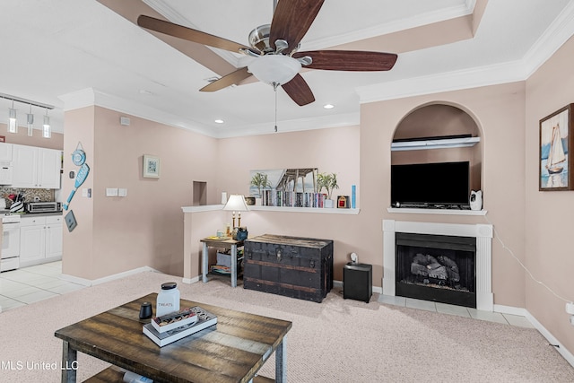 carpeted living room featuring ornamental molding, track lighting, and ceiling fan