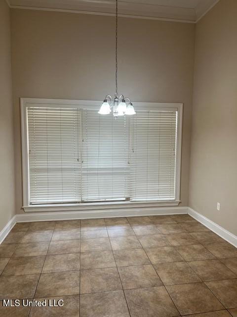 unfurnished dining area featuring tile patterned floors, a chandelier, baseboards, and ornamental molding