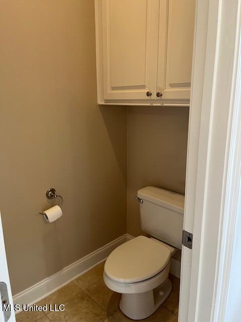 bathroom with tile patterned flooring, toilet, and baseboards