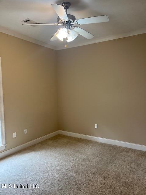 spare room featuring light carpet, baseboards, crown molding, and a ceiling fan