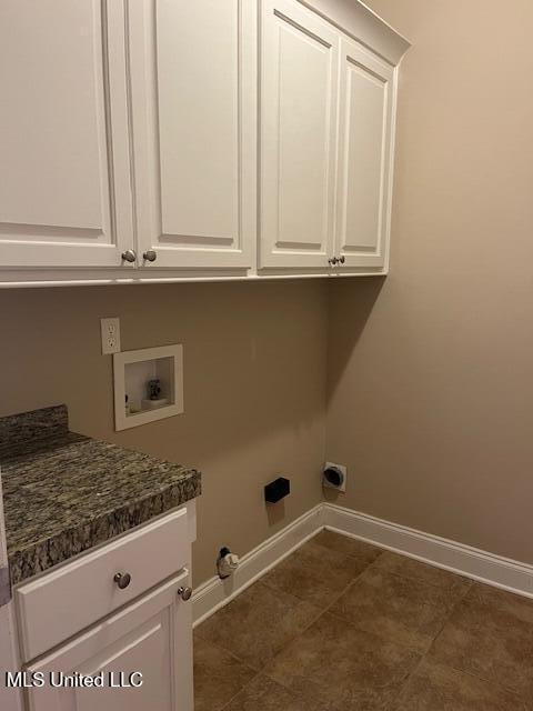 laundry room with dark tile patterned floors, baseboards, cabinet space, and hookup for a washing machine