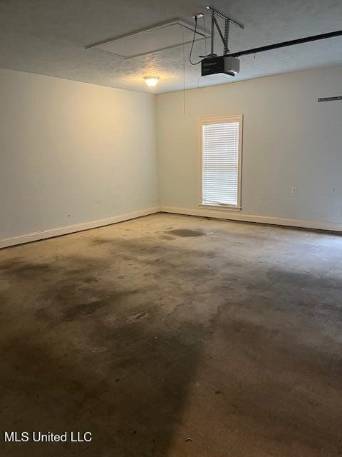 garage with baseboards and a garage door opener