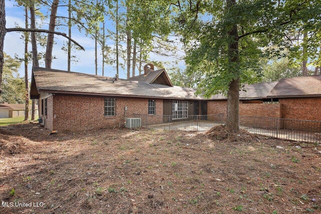 rear view of house featuring central AC unit and a patio