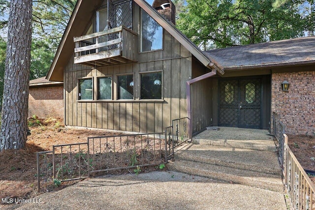 view of exterior entry with a balcony