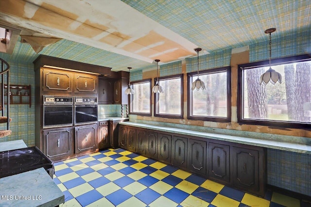 kitchen featuring hanging light fixtures, dark brown cabinets, and oven