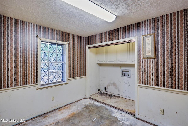 clothes washing area with washer hookup, cabinets, and a textured ceiling