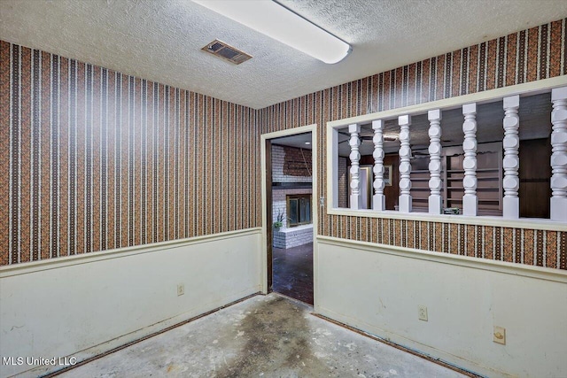 unfurnished room with a textured ceiling and concrete floors