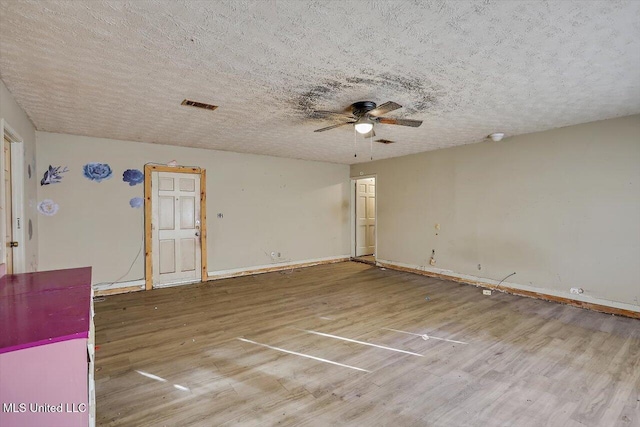 unfurnished room featuring ceiling fan, wood-type flooring, and a textured ceiling