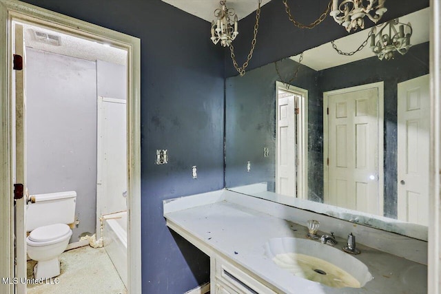 bathroom featuring vanity, a washtub, and toilet