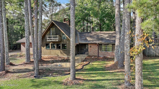 view of front of house with a balcony and a front yard