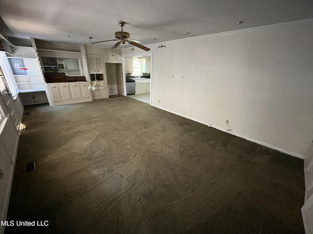 unfurnished living room with ceiling fan, ornamental molding, and dark carpet