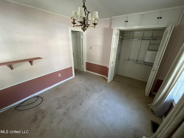 unfurnished bedroom with crown molding, light carpet, a chandelier, and a closet