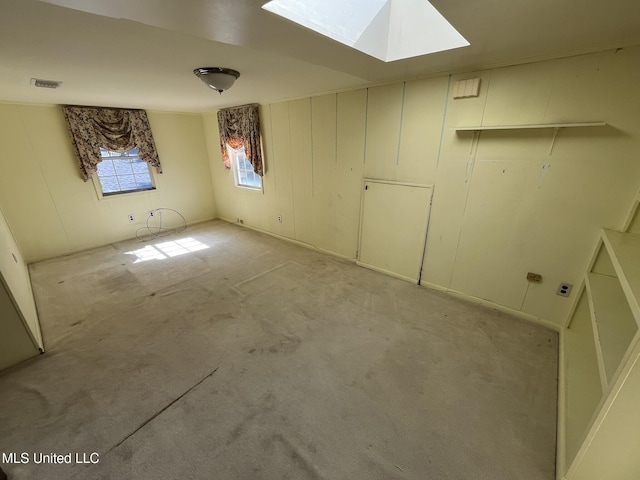 carpeted spare room featuring a skylight