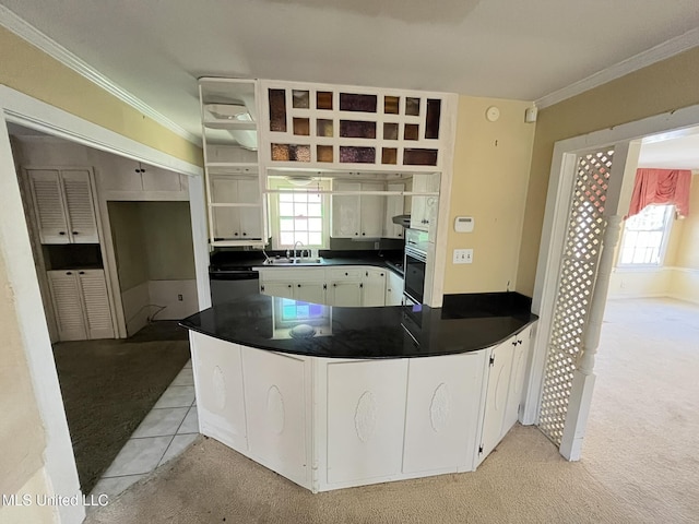 kitchen with white cabinetry, ornamental molding, light colored carpet, kitchen peninsula, and stainless steel appliances