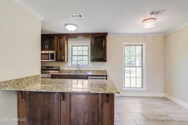14667 Cable Bridge Rd, Gulfport, MS 39503 - kitchen with stainless steel appliances, a sink, a peninsula, dark brown cabinetry, and baseboards