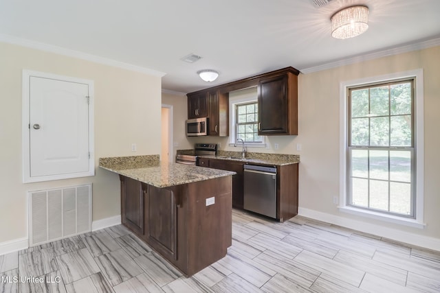 14667 Cable Bridge Rd, Gulfport, MS 39503 - kitchen with appliances with stainless steel finishes, a sink, baseboards, ornamental molding, and a peninsula