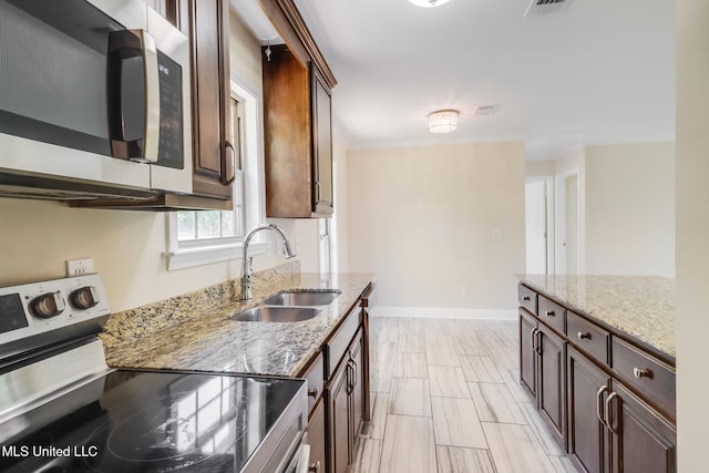 14667 Cable Bridge Rd, Gulfport, MS 39503 - kitchen with stainless steel appliances, a sink, light stone counters, and dark brown cabinets
