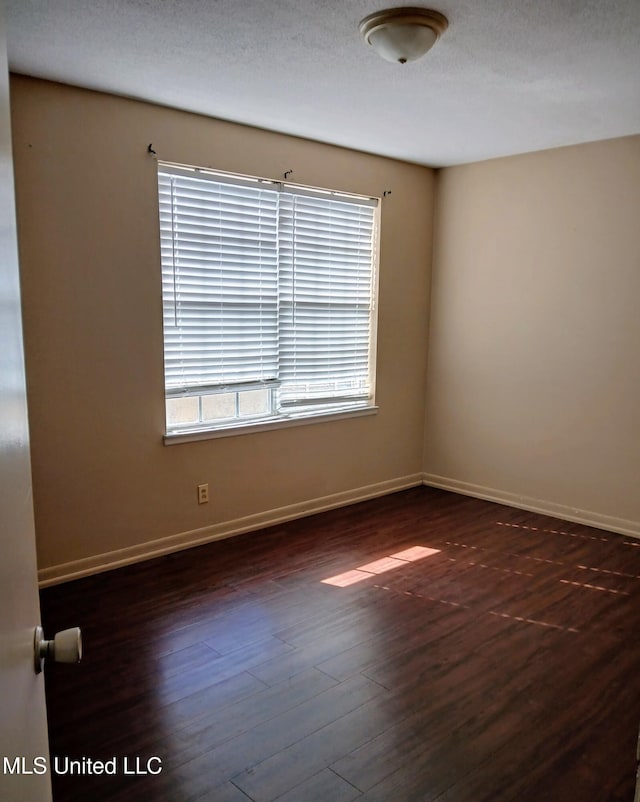 empty room with dark hardwood / wood-style flooring