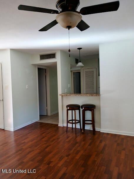 kitchen featuring ceiling fan, dark hardwood / wood-style flooring, and a breakfast bar