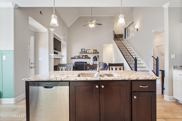 kitchen featuring a sink, decorative light fixtures, stainless steel dishwasher, and dark brown cabinetry