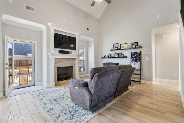 living area featuring wood finish floors, visible vents, and ornamental molding