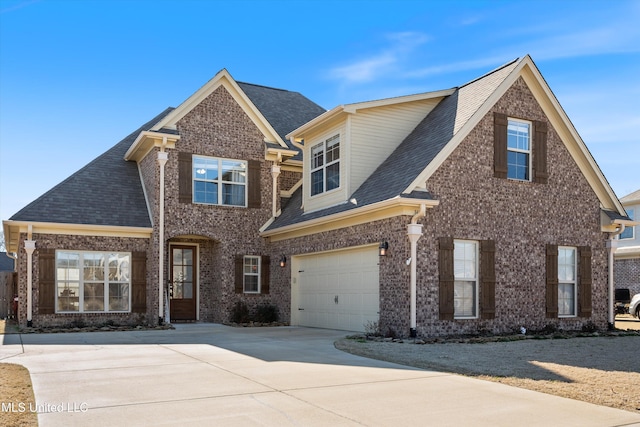 view of front facade with brick siding, driveway, an attached garage, and a shingled roof