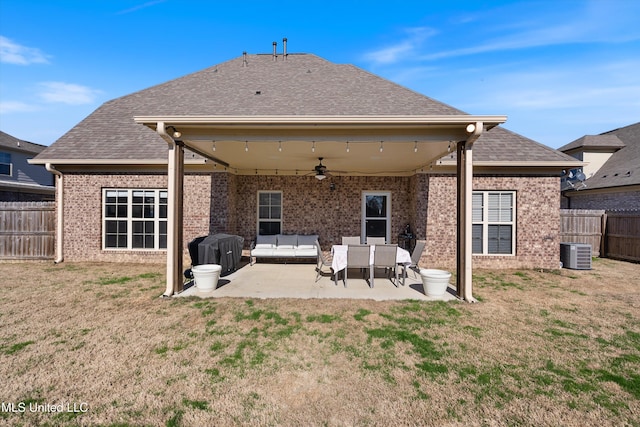 rear view of house with brick siding, ceiling fan, a yard, a fenced backyard, and a patio