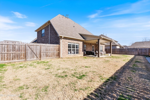 back of property with a patio, a fenced backyard, a yard, brick siding, and ceiling fan