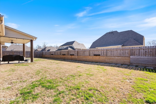 view of yard with a ceiling fan, a patio area, and a fenced backyard