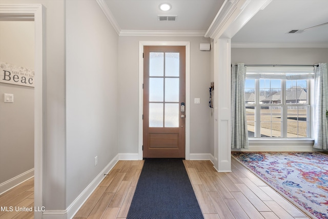 entryway with visible vents, ornamental molding, and wood tiled floor