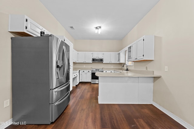 kitchen with dark wood-type flooring, white cabinetry, appliances with stainless steel finishes, and kitchen peninsula