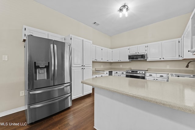 kitchen featuring kitchen peninsula, sink, appliances with stainless steel finishes, white cabinets, and dark hardwood / wood-style flooring