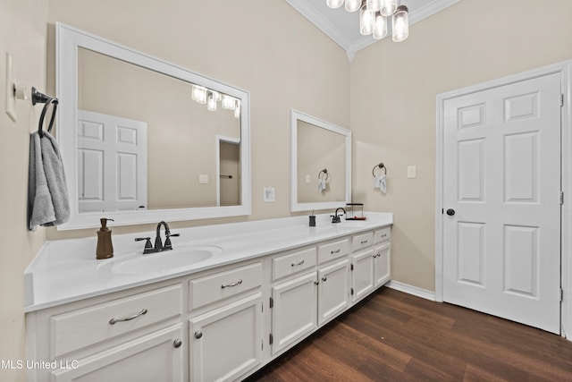 bathroom featuring lofted ceiling, vanity, an inviting chandelier, hardwood / wood-style flooring, and ornamental molding