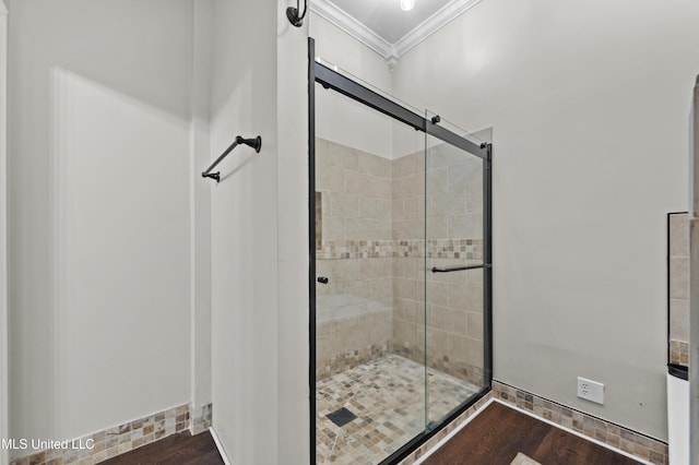 bathroom featuring a shower with shower door, wood-type flooring, and ornamental molding