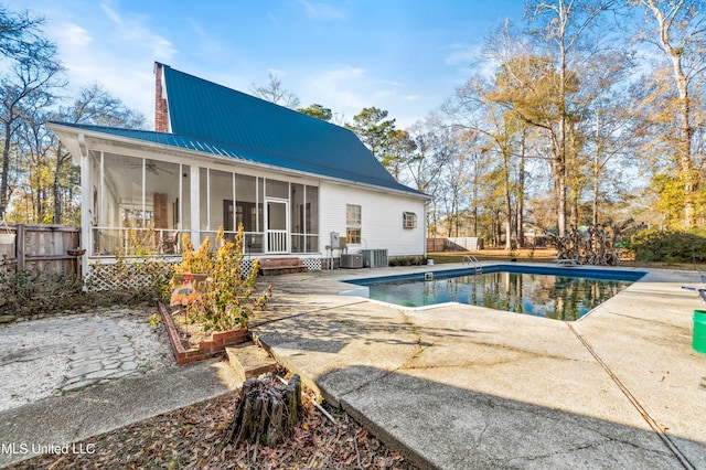 view of pool featuring cooling unit, a patio, and a sunroom