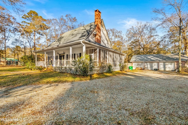 view of side of property featuring a garage, a porch, and an outdoor structure