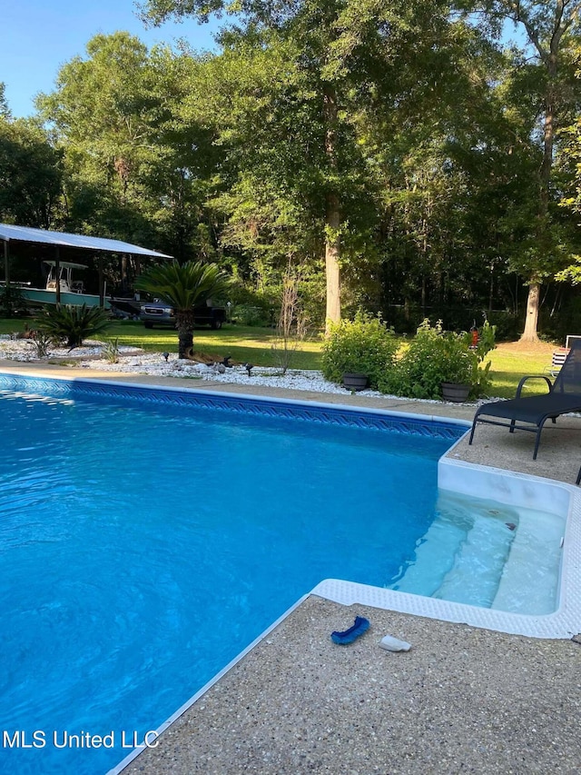 view of pool featuring a yard