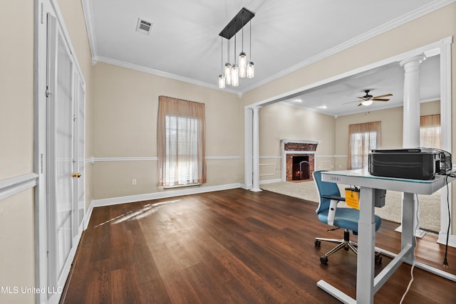 office featuring ceiling fan with notable chandelier, dark hardwood / wood-style flooring, crown molding, and a fireplace