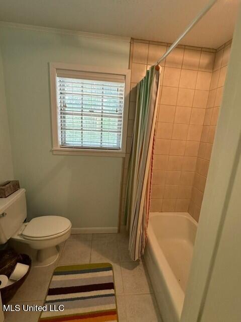 full bathroom featuring shower / tub combo with curtain, ornamental molding, toilet, and tile patterned floors