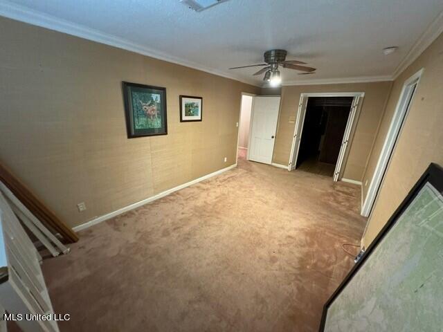 unfurnished bedroom featuring baseboards, a closet, crown molding, and carpet
