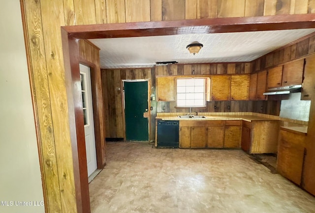 307 Pleasant Valley Dr, Vicksburg, MS 39180 - kitchen with black dishwasher, wood walls, brown cabinetry, a sink, and light countertops