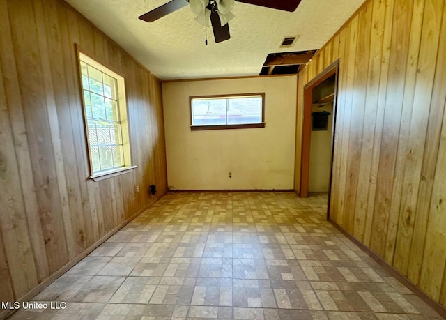 307 Pleasant Valley Dr, Vicksburg, MS 39180 - unfurnished bedroom with wooden walls, multiple windows, a textured ceiling, brick patterned floors, and ceiling fan