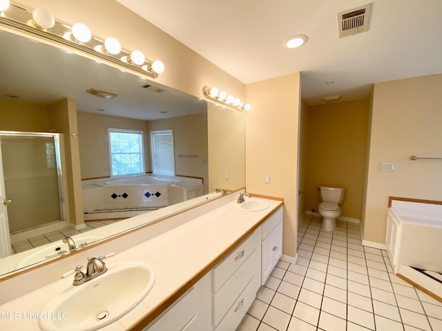 full bathroom featuring tile patterned floors, vanity, shower with separate bathtub, and toilet