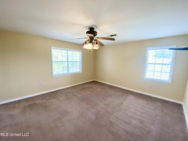 carpeted spare room featuring ceiling fan and a healthy amount of sunlight