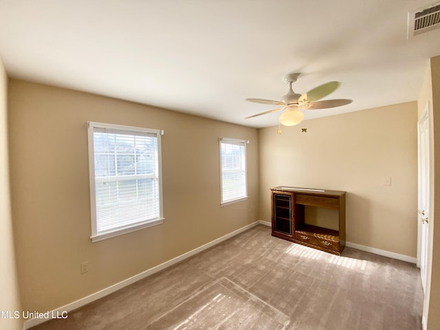 spare room featuring plenty of natural light, ceiling fan, and light colored carpet