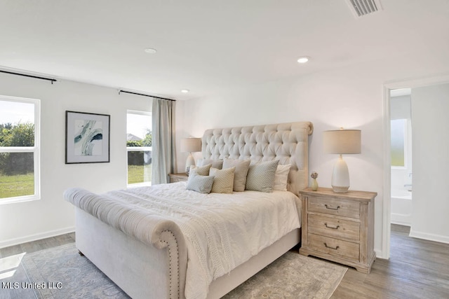 bedroom with connected bathroom and light hardwood / wood-style floors