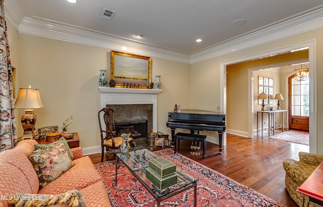 living room with crown molding, a chandelier, and hardwood / wood-style flooring